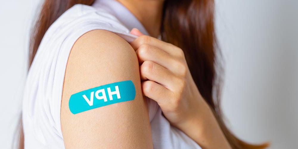 Arm with bandage that says "HPV" to show where an HPV vaccine was given.